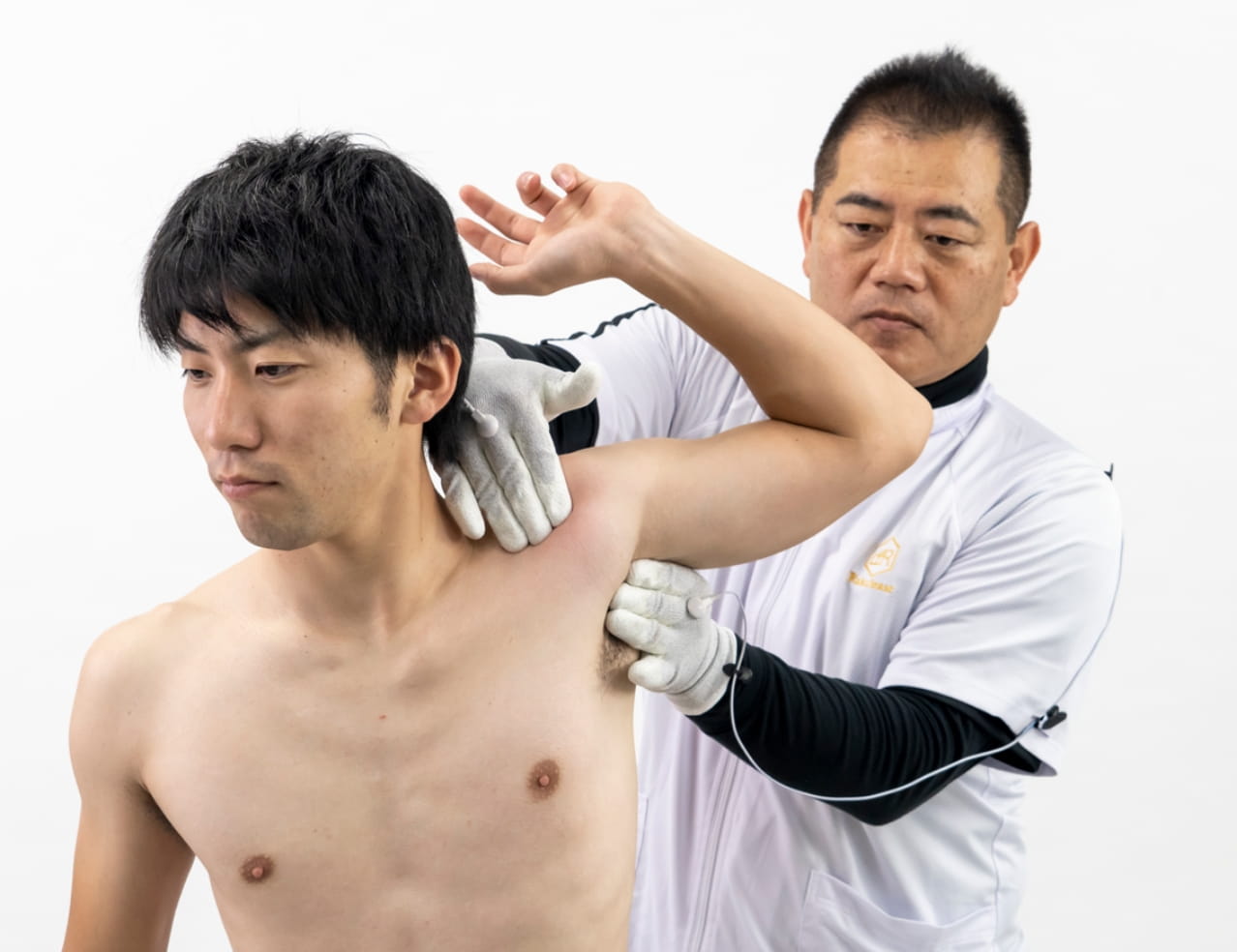 肘にラクリスグローブで施術を受けるアスリート
